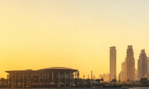 Dubai towers at sunset above a long low-roofed building (AI-generated image)