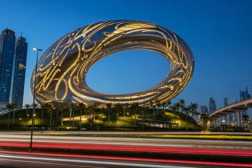 The Museum of the Future at blue hour, its steel ring lit through curved window openings (AI-generated image)